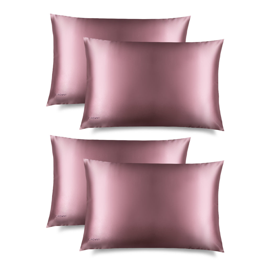 Four pink silk pillowcases on a white background