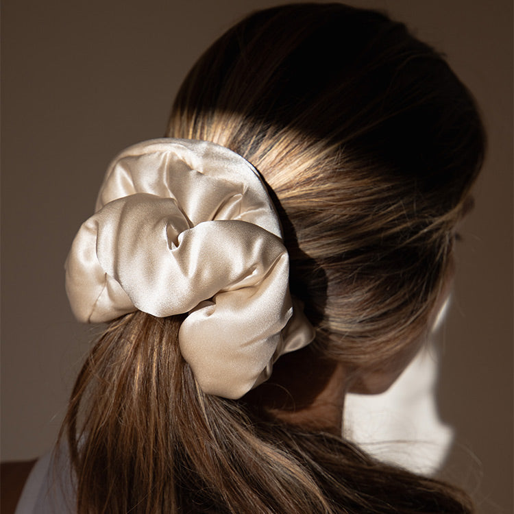 Lifestyle image of a girl wearing a drowsy dusty gold pillow scrunchie