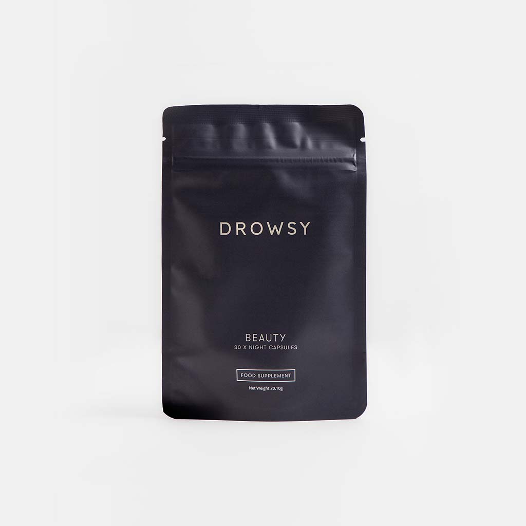A black resealable pouch labeled drowsysleepco Supplements - Beauty, containing 30 night capsules for a youthful complexion, stands upright against a plain light gray background.