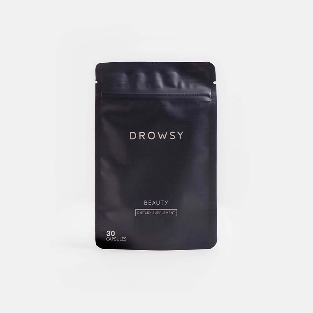 A dark, resealable pouch labeled us.drowsysleepco Supplements - Beauty contains 30 capsules supporting collagen synthesis for youthful skin. The minimalist packaging is displayed against a plain white background.