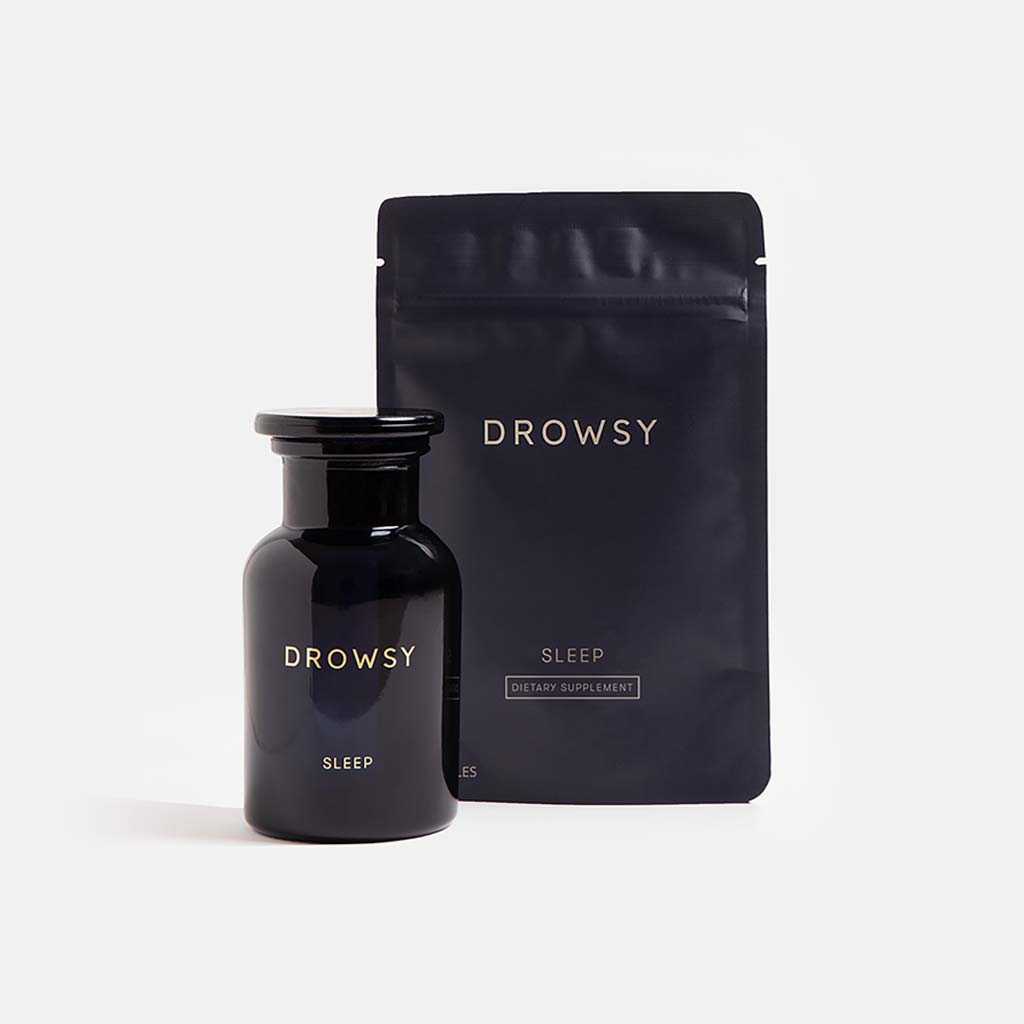 A dark glass bottle and resealable pouch labeled Supplements - Sleep from us.drowsysleepco feature minimalist gold text on black, shown against a plain white backdrop.