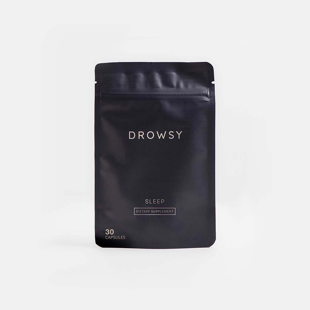 A black resealable pouch labeled us.drowsysleepco Supplements - Sleep contains 30 capsules of a nightly sleep aid. The minimal, white-on-black packaging is designed to help you relax before bed.