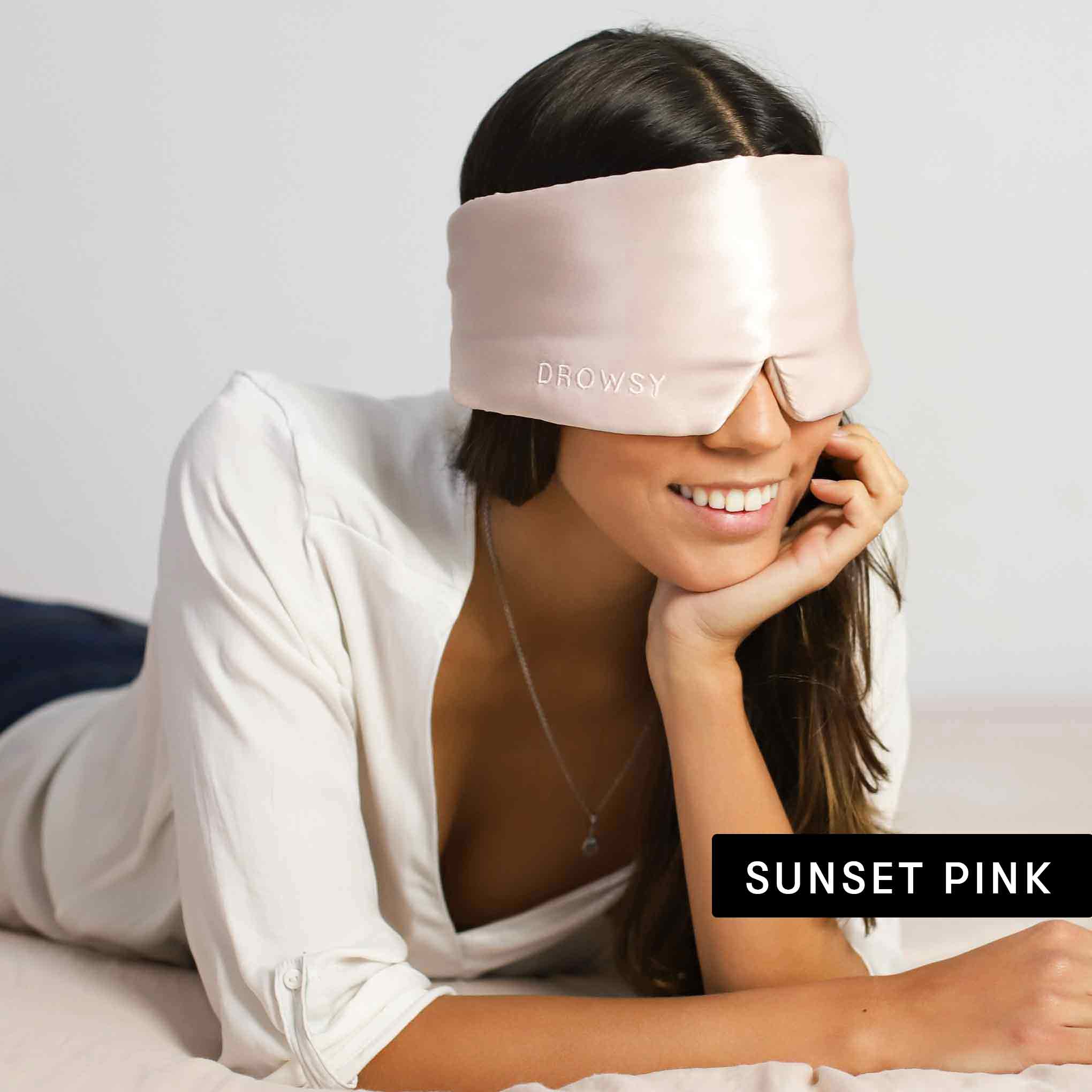 A woman relaxes into beauty sleep, wearing a Drowsy Lovers Pack luxury silk eye mask.