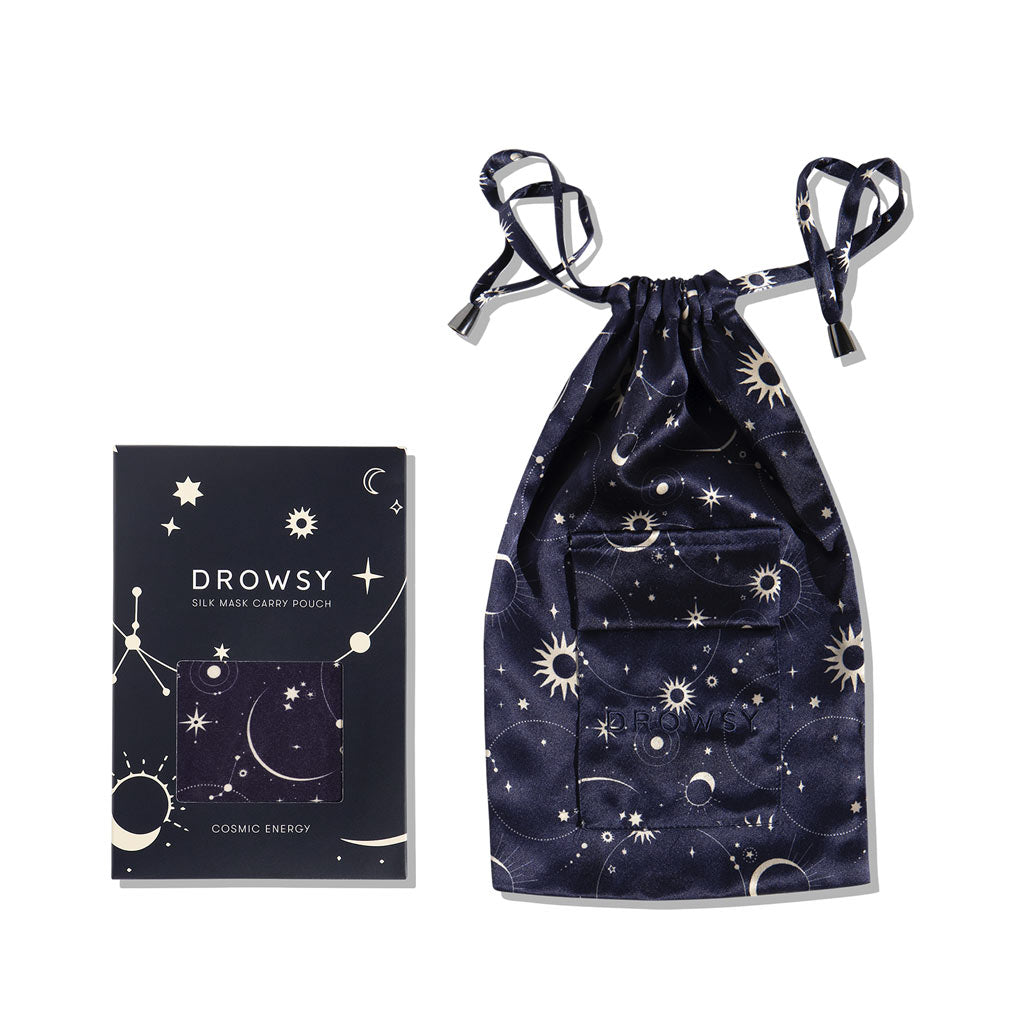 The us.drowsysleepco Cosmic Energy Silk Carry Pouch in dark blue features a celestial stars and moons pattern, displayed next to the matching luxury sleep mask box—both crafted from pure mulberry silk.