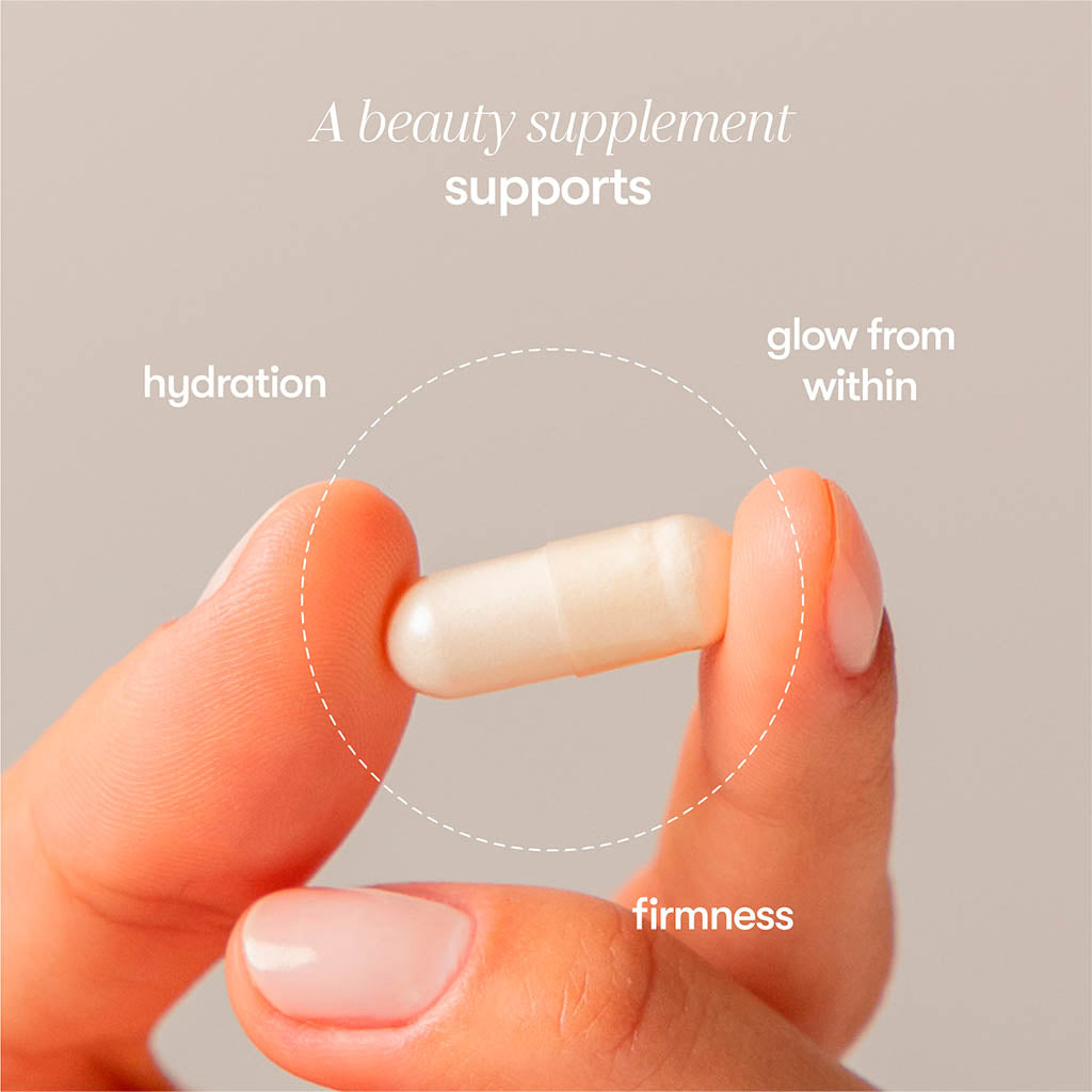 A hand holds a white capsule from us.drowsysleepcos Supplements - Beauty, designed to support hydration, collagen synthesis, and a youthful complexion for glowing, firm skin.
