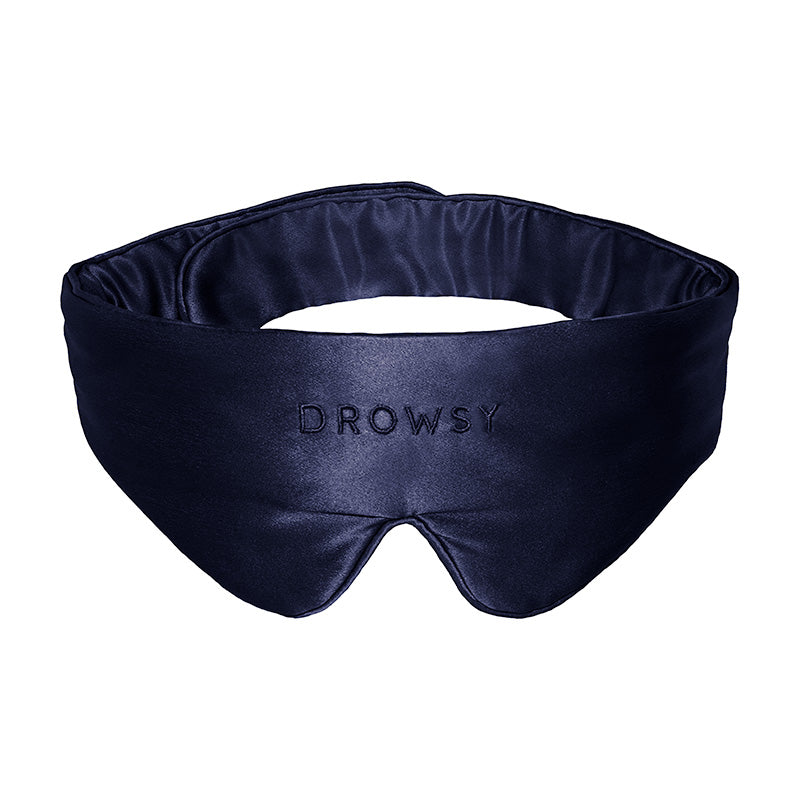 The Featherweight Silk Eye Mask in Midnight Blue by us.drowsysleepco is crafted from luxurious mulberry silk and features "DROWSY" embroidered on the front. This cushioned sleep mask is designed to fully cover your eyes, providing ultimate comfort and effective light blocking.