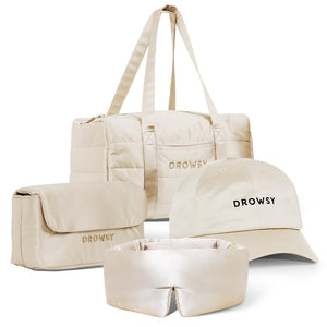 The Perfect scape bundle - Dusty Gold by drowsysleepco includes a beige duffel, toiletry bag, Drowsy-branded cap, and silk sleep mask—stylish essentials for beauty sleep wherever you go.