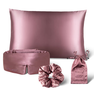 The drowsysleepco Sensual sleep bundle - Damask Rose features mauve pink satin accessories—sleep mask, pillowcase, scrunchie, and pouch—elegantly arranged on a white background for a touch of luxury.