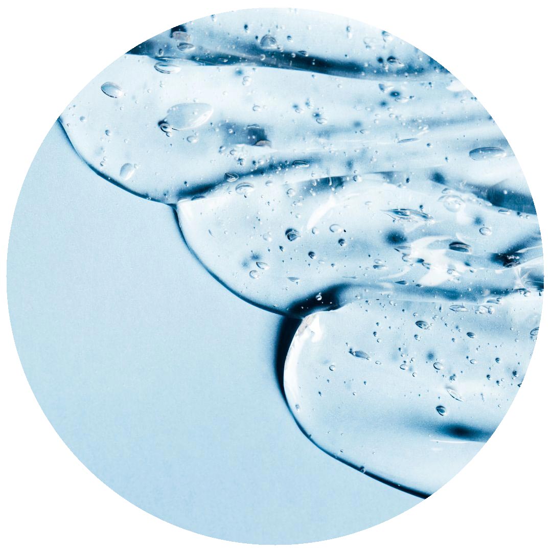 Clear gel with small bubbles spread on a light blue surface, viewed close up in a circular frame.