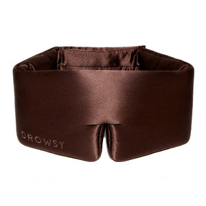 The Cocoa Glow by drowsysleepco is a brown, padded silk sleep mask embroidered with "Drowsy," designed to fully block out light and offer comfort around your eyes and head.
