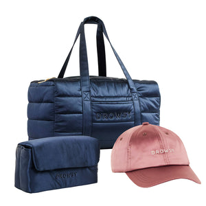 The Drowsy Weekend Collection - Midnight Blue + Damask Rose by Drowsy includes a navy puffer duffle bag, matching navy pouch, and a light pink cap, each embroidered with Drowsy.
