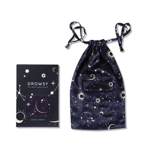 The us.drowsysleepco Cosmic Energy Silk Carry Pouch in dark blue features a celestial stars and moons pattern, displayed next to the matching luxury sleep mask box—both crafted from pure mulberry silk.