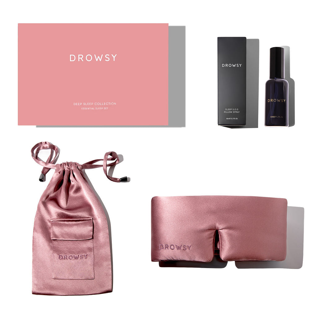 The Damask Rose - Deep Sleep Collection by us.drowsysleepco includes a pink silk sleep mask with pouch, deep sleep pillow spray in a black bottle with box, all packaged in a pink Drowsy Deep Sleep Collection box.