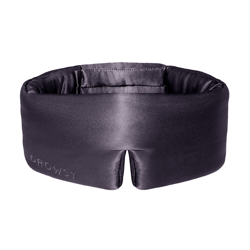 Experience ultimate beauty sleep with the Moonlight Shadow by us.drowsysleepco—a padded black silk eye mask featuring a wide band and a stylish front split, elegantly embroidered with "DROWSY" on the left side.