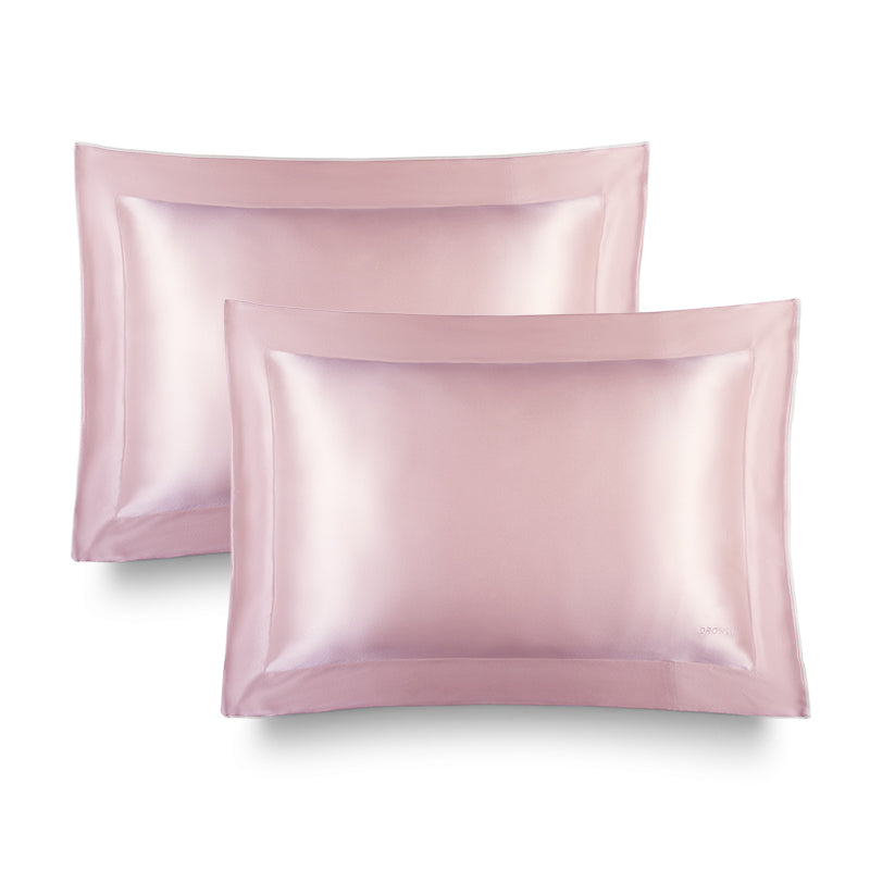 Two Hyalo Pillowcases in Petal Pink by us.drowsysleepco are displayed overlapping on a white background. Featuring a smooth, shiny texture and visible edge stitching, these pillowcases evoke the luxury of silk while supporting overnight hydration and helping your skin retain moisture as you sleep.